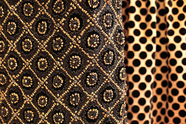 L:  Black All-Over Beading Evening Gown.Black cut velvet lace gown encrusted with rhinestone and raised beading in jet and bugle beads in a diamond pattern.  R:  Gold and Black Ensemble.Gold ottoman/black velvet polka dot ensemble with a detachable sk